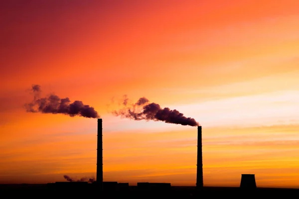 Kızıl gündoğumu veya gündoğumu arka planda termal güç istasyonu buharlama boruları siluetleri. Kırmızı, turuncu, gül, Kızıl, Kızıl, mor, menekşe ve mavi bulutlu gökyüzü bulutlu