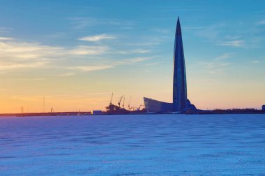 Buz ve kar güneş ışınları Neva Nehri'nin ağzında şehirde Petersburg yakınındaki Lahta Merkezi gökdelen buidling bitiş shore körfezde kaplı