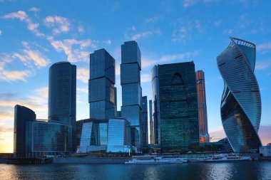 Moskova/ Rusya 19 Nisan 2019: Moskova şehrinin eşsiz gökdeleni, Rusya'nın başkentinin kalbindeki modern ofis merkezi akşam saatlerinde Moskva nehri kıyısında batan güneşin ışınlarıyla