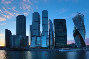 Moskova/ Rusya 19 Nisan 2019: Moskova şehrinin eşsiz gökdeleni, Rusya'nın başkentinin kalbindeki modern ofis merkezi akşam saatlerinde Moskva nehri kıyısında batan güneşin ışınlarıyla