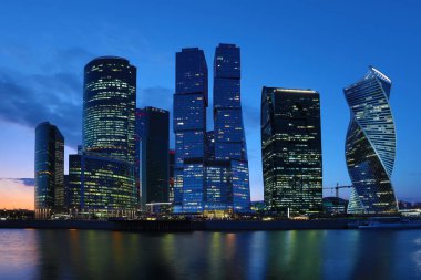 Moskova/ Rusya 19 Nisan 2019: Moskova şehrinin eşsiz gökdeleni, Rusya'nın başkentinin kalbindeki modern ofis merkezi akşam saatlerinde Moskva nehri kıyısında batan güneşin ışınlarıyla