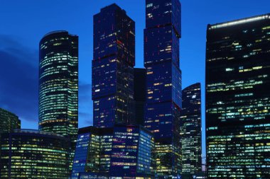 Moskova/ Rusya 19 Nisan 2019: Moskova şehrinin eşsiz gökdelenlerinin pencereleri, Moskova'nın modern ofis merkezi akşam Moskva nehri kıyısında batan güneşin ışınları