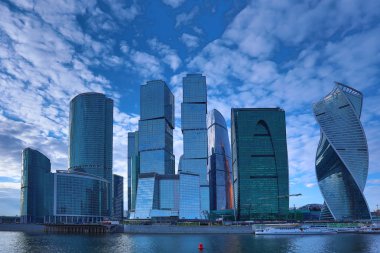 Moskova/ Rusya 19 Nisan 2019: Moskova şehrinin eşsiz gökdeleni, Rusya'nın başkentinin kalbindeki modern ofis merkezi akşam saatlerinde Moskva nehri kıyısında batan güneşin ışınlarıyla