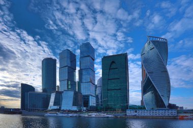 Moskova/ Rusya 19 Nisan 2019: Moskova şehrinin eşsiz gökdeleni, Rusya'nın başkentinin kalbindeki modern ofis merkezi akşam saatlerinde Moskva nehri kıyısında batan güneşin ışınlarıyla