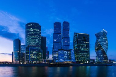 Moskova/ Rusya 19 Nisan 2019: Moskova şehrinin eşsiz gökdeleni, Rusya'nın başkentinin kalbindeki modern ofis merkezi akşam saatlerinde Moskva nehri kıyısında batan güneşin ışınlarıyla