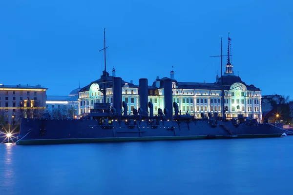 Russian cruiser Aurora in the mouth of Neva river in Petersburg on the background of Nakhimov Naval School in the evening. The navy museum and the symbol of Great October revolution and Petersburg