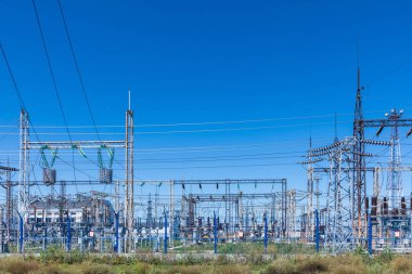Güneşli yaz havasında mavi gökyüzünün arka planında elecric trafo kutupları ve telleri
