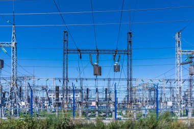 Güneşli yaz havasında mavi gökyüzünün arka planında elecric trafo kutupları ve telleri
