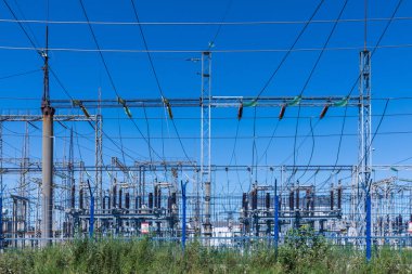 Güneşli yaz havasında mavi gökyüzünün arka planında elecric trafo kutupları ve telleri