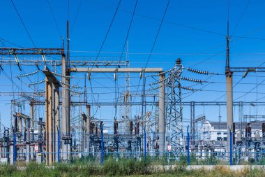 Güneşli yaz havasında mavi gökyüzünün arka planında elecric trafo kutupları ve telleri