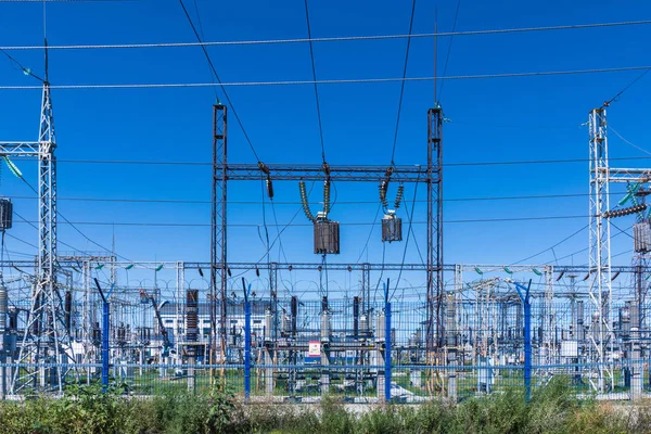 Güneşli yaz havasında mavi gökyüzünün arka planında elecric trafo kutupları ve telleri