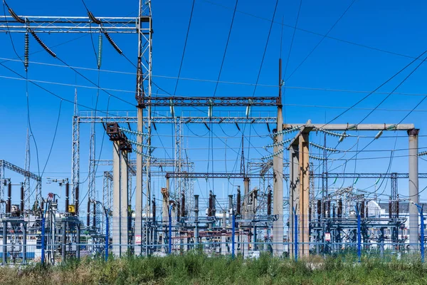Güneşli yaz havasında mavi gökyüzünün arka planında elecric trafo kutupları ve telleri