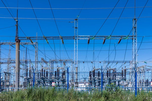 Güneşli yaz havasında mavi gökyüzünün arka planında elecric trafo kutupları ve telleri