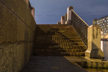 Saint Petersburg, Rusya 'da Neva, Fontanka ya da Moyka nehrinin granit setinin merdivenleri bulutlu bir sonbahar akşamında