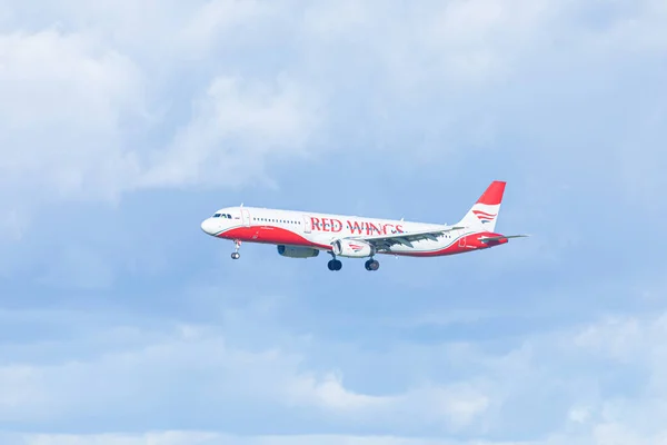 Pulkovo havaalanı Saint Petersburg / Rusya yakınları - 19 Eylül 2020: Yandan iniş yapan veya mavi bulutlu gökyüzünün arka planında havalanan kırmızı kanatlı uçak