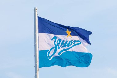 Saint Petersburg / Rusya 'daki Zenit Arena - Ekim 03 2020: Mavi bulutlu gökyüzünün arka planında resmi futbol veya futbol kulübü Zenit bayrağı. Rusça yazıt, Zenit futbol kulübünün adı anlamına gelir