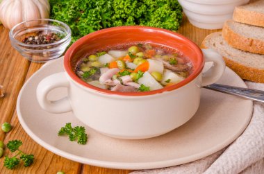 Yeşil bezelye ve sebze ahşap arka plan üzerinde bir kase ile tavuk çorbası