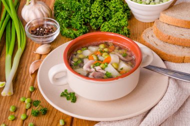 Yeşil bezelye ve sebze ahşap arka plan üzerinde bir kase ile tavuk çorbası