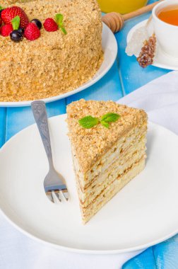 Üstünde ekşi krema ve böğürtlen olan ev yapımı ballı pasta.