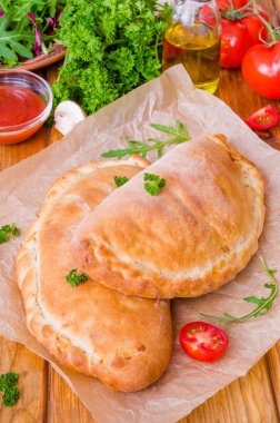 Pizza Calzone domates sosu, peynir, otlar, mantar ve sosis
