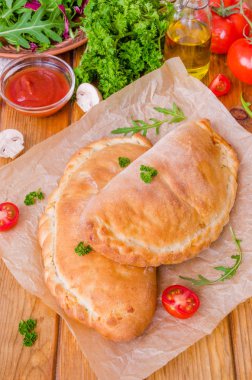 Pizza Calzone domates sosu, peynir, otlar, mantar ve sosis