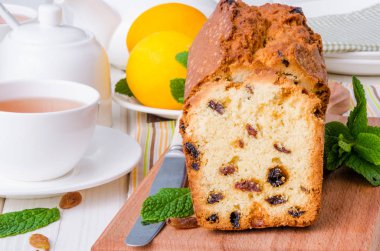 Limonlu kek kurutulmuş cranberries ve beyaz ahşap zemin üzerine kuru üzüm ile