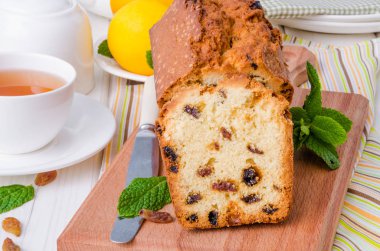 Limonlu kek kurutulmuş cranberries ve beyaz ahşap zemin üzerine kuru üzüm ile