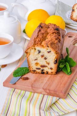 Limonlu kek kurutulmuş cranberries ve beyaz ahşap zemin üzerine kuru üzüm ile