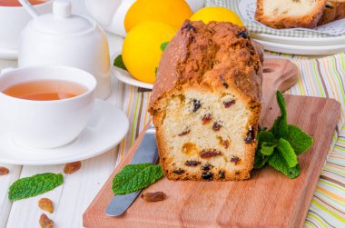 Limonlu kek kurutulmuş cranberries ve beyaz ahşap zemin üzerine kuru üzüm ile