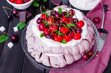 Çikolata Pavlova kek krem şanti ve siyah ahşap zemin kiraz