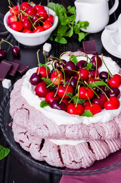 巧克力帕夫洛娃蛋糕与奶油和樱桃在黑色的木质背景 — 图库照片