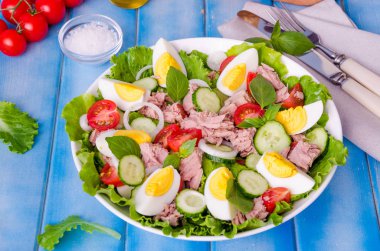 Ton balığı salatası marul yaprakları, haşlanmış yumurta, domates, salatalık, soğan ve fesleğen