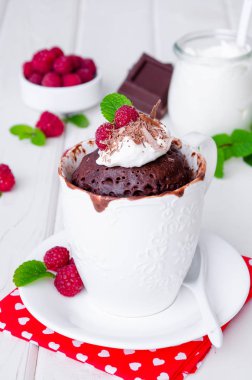 Çikolata kupa cupcake krema, çikolata ve Beyaz ahşap zemin üzerinde taze frambuaz.