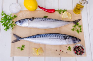 Taze balık. Beyaz arka planda tuz, limon ve baharatlarla uskumru. Otlar ile balık pişirme.