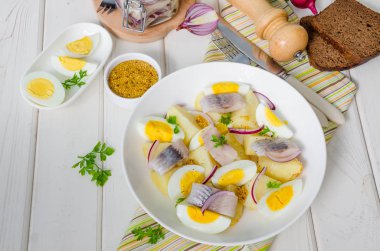 Tuzlu balık, haşlanmış yumurta, soğan ve maydanoz yaprakları ile Patates salatası.