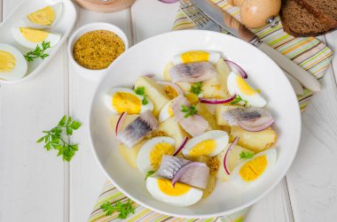 Tuzlu balık, haşlanmış yumurta, soğan ve maydanoz yaprakları ile Patates salatası.