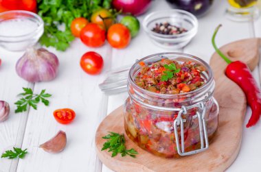 Cam bir kavanozda domates ve közlenmiş biber ile Patlıcan havyar