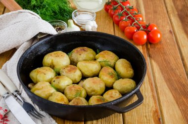 Sarımsak ve dereotu ile dökme demir tavada Kızarmış Genç Patates. Rustik stil.