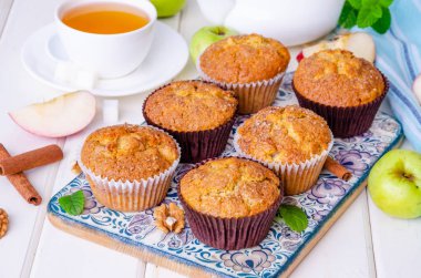 Beyaz ahşap arka plan üzerinde ceviz ve tarçın ile ev yapımı gevrek elma muffins.