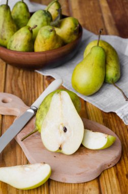 koyu ahşap bir arka plan üzerinde kil bir kase taze olgun armut. Rustik stil