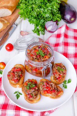 Beyaz bir tabak üzerinde patlıcan havyar ile gevrek tost