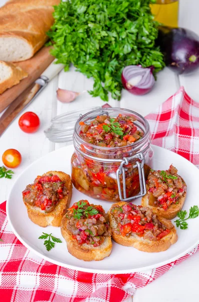 Crispy toasts with eggplant caviar on a white plate