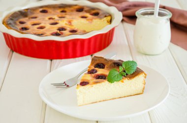 Beyaz ahşap arka plan üzerinde kiraz ve ekşi krema ile Diyet sağlıklı süzme peynir kek.