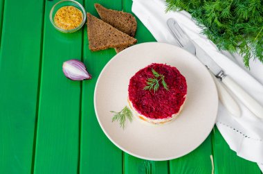 Geleneksel Rus salata ringası tabakta kürkün altında. Tuzlu balıklı salata ve haşlanmış sebze..