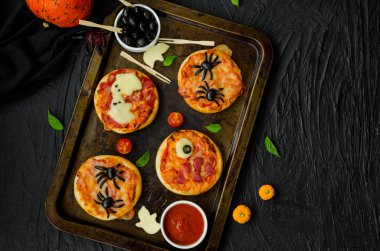 Siyah bir arka plan üzerinde Halloween Mini Pizza Monsters. Örümcek Pizza, Hayalet Pizza, Canavar Pizza. Cadılar Bayramı partisi için gıda fikri.