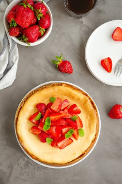 New York 'ta ev yapımı cheesecake, beyaz tabakta taze çilek ve gri taşlı arka planda kahve. Amerikan mutfağı.