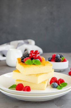 Ev yapımı süzme peynir güveci, taze böğürtlen ve beyaz tabakta nane şekeri. Sağlıklı kahvaltı. Dikey, boşluğu kopyala