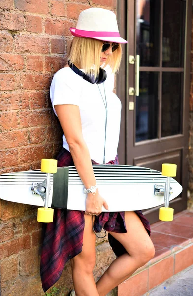Ung Kvinna Med Skateboard Och Hörlurar — Stockfoto