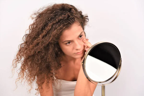孤立した白い背景に鏡を通して見る巻き毛の若いアフロ女性 — ストック写真