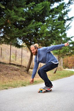 Genç adam kaykay yapıyor ve eğleniyor.